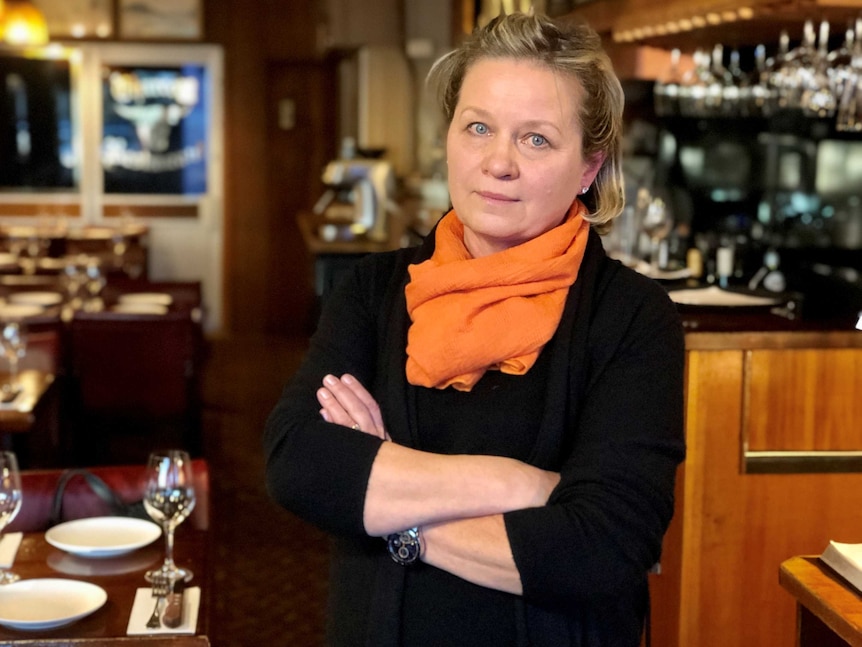 Charcoal Restaurant owner Anna Gray stands in a restaurant.