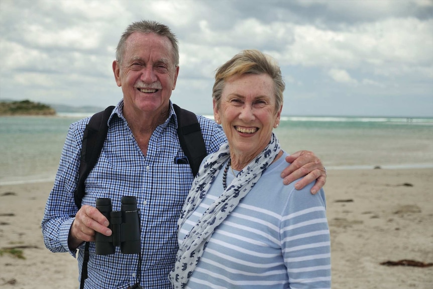 A couple on the beach smiling.