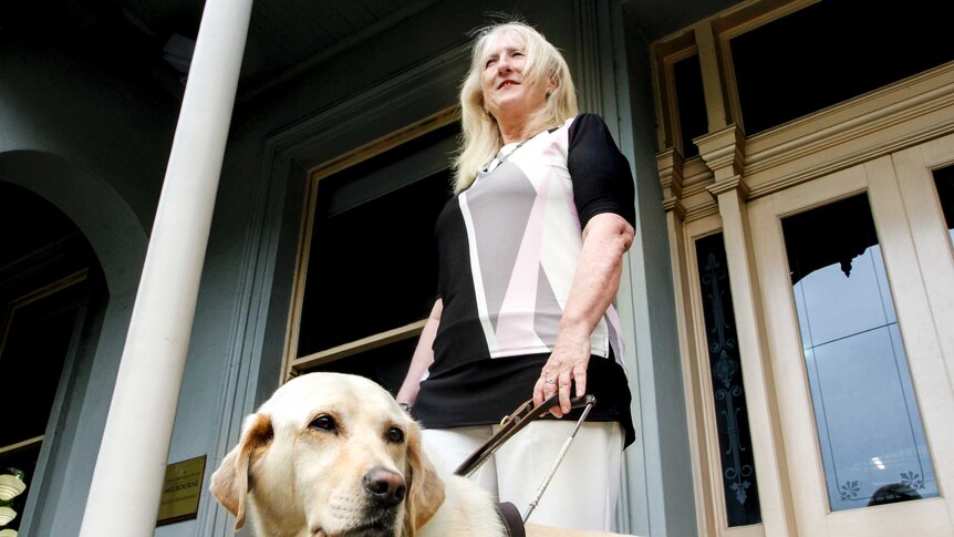 Bionic eye recipient Dianne stands with her guide dog