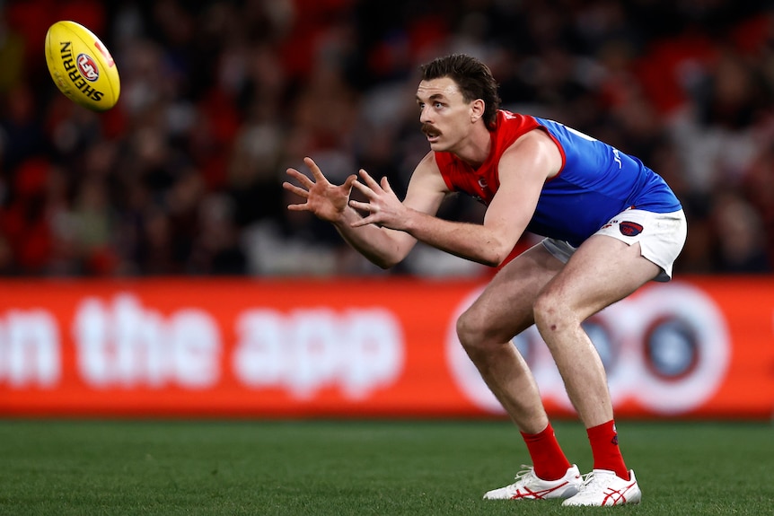 Jake Lever crouches as he prepares to mark the oncoming ball