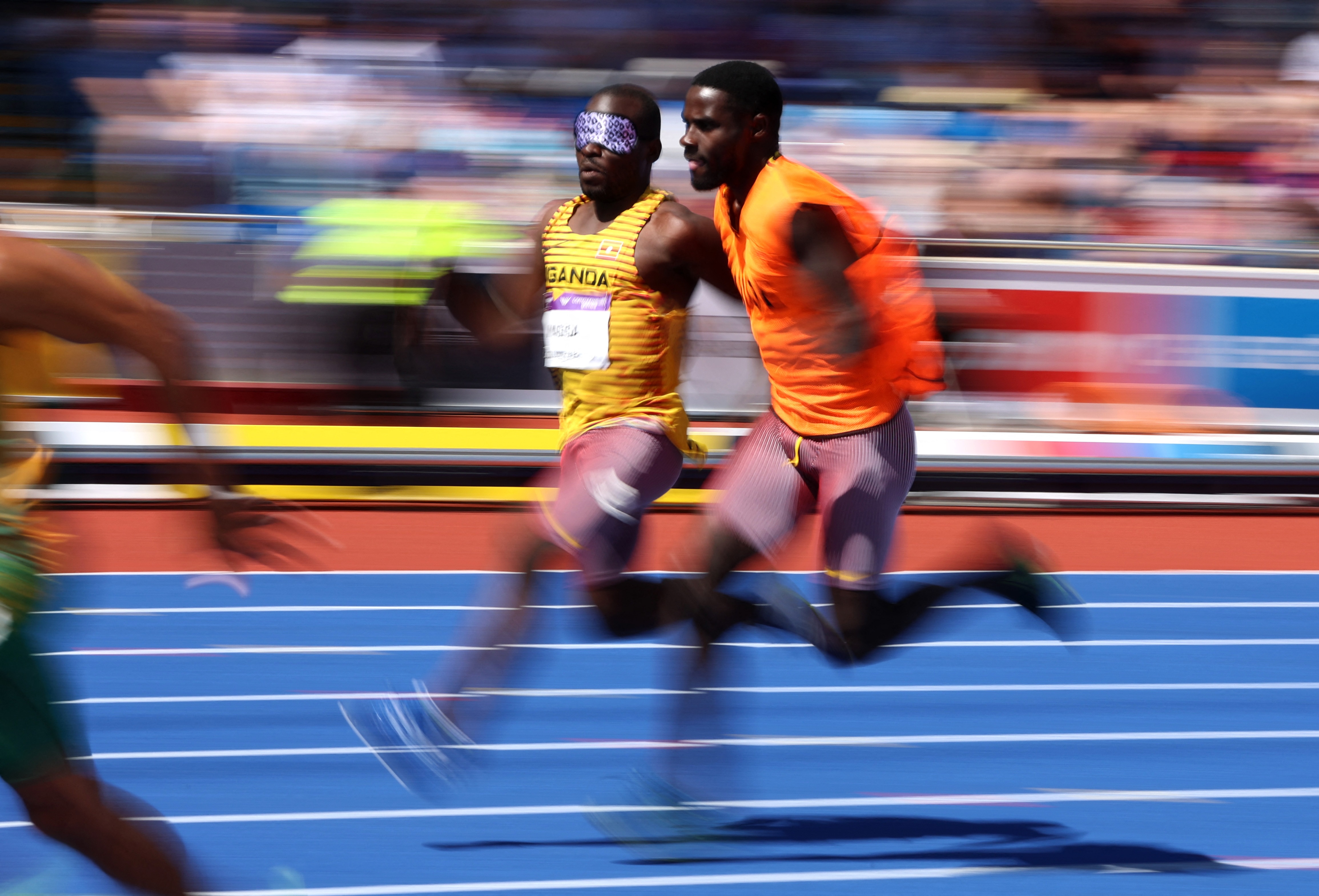 Two men, one wearing an eye shield, during a running race