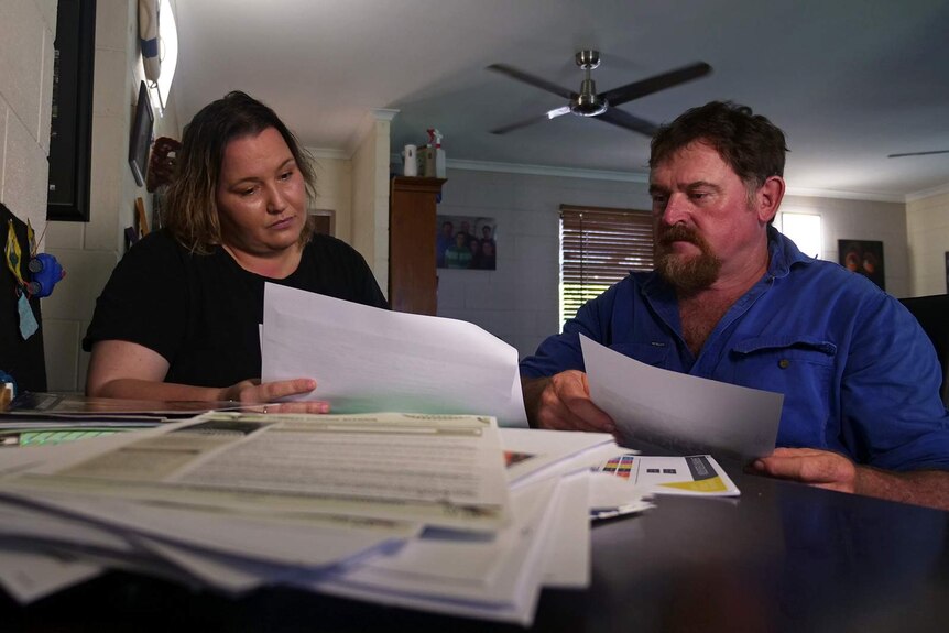 Sam Baker and her partner Paul Miller pore over paperwork in their Palmerston home.