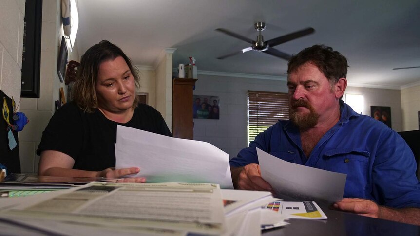 Sam Baker and her partner Paul Miller pore over paperwork in their Palmerston home.
