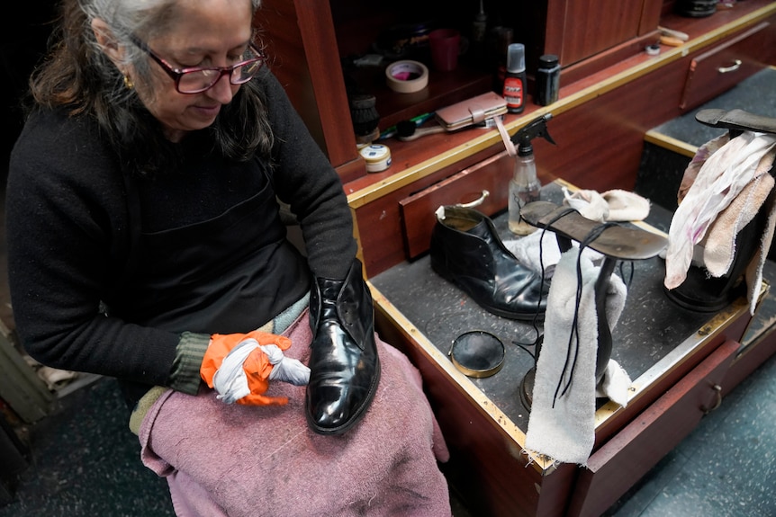 A woman polishing a boot