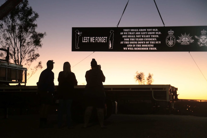 The dawn service at Anzac Hill in Alice Springs with a banner showing The Ode for the Fallen.