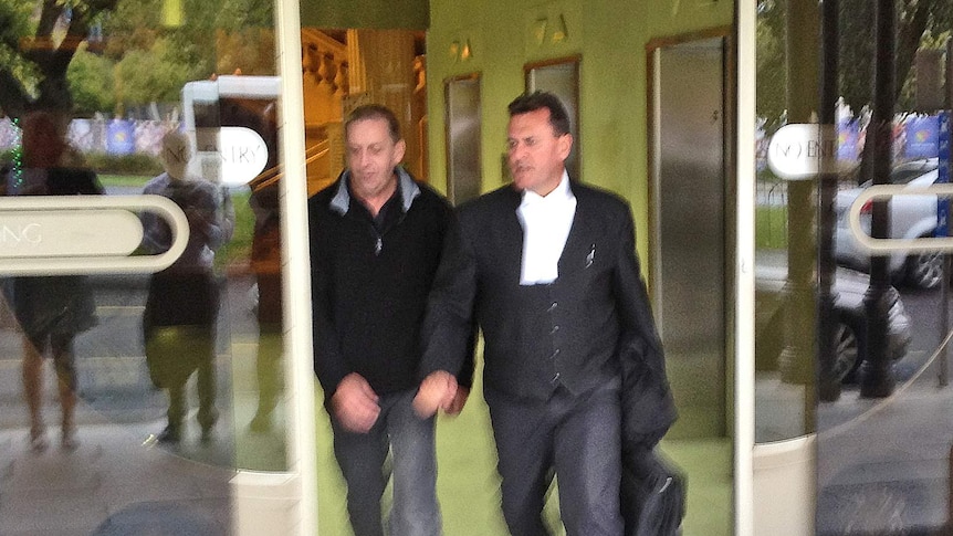 Richard Edward (L) leaves court with his lawyer