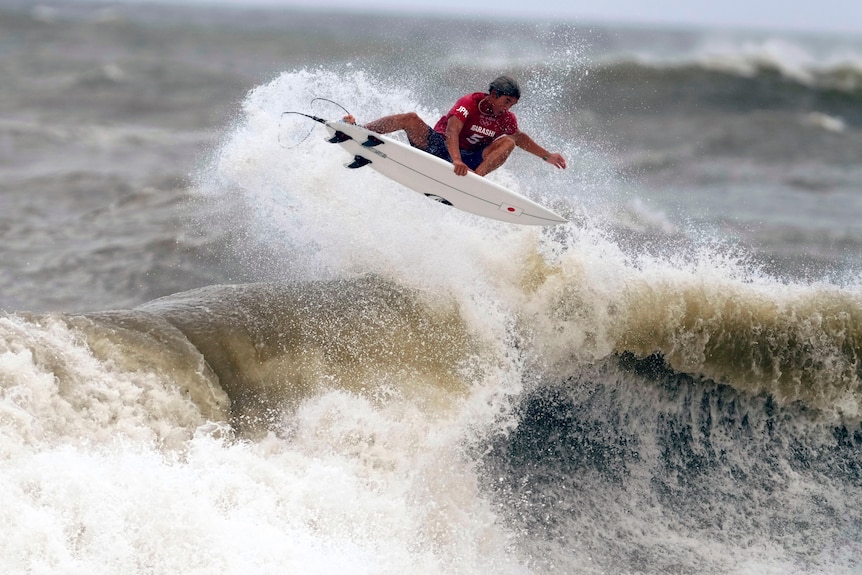 Kanoa Igarashi holds onto his surfboard as he gets air