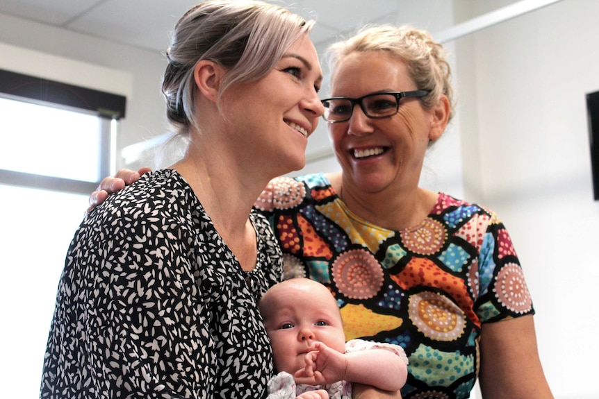 two women laughing with baby