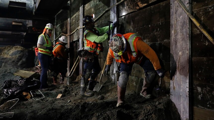 Workers nail boards to the wall at the construction site of the Metro Purple Line extension in Los Angeles.