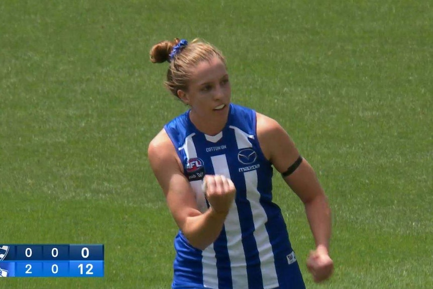 North Melbourne AFLW player Emma King pumps her fist after kicking a goal against the Geelong Cats.