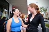Tara Gallagher, left, organiser of the Croissant Run Club smiling and talking to a fellow runner outside a Sydney cafe