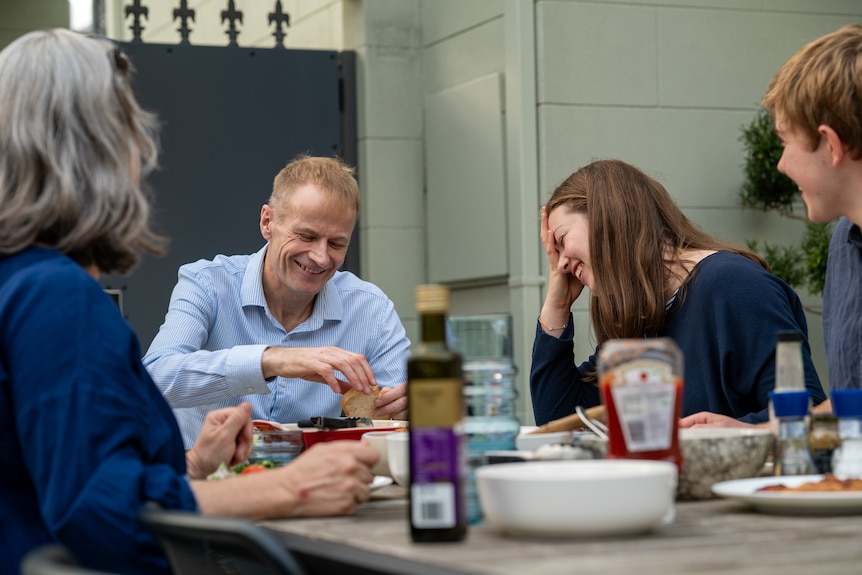 Richard and his oldest daughter laughing at the table.