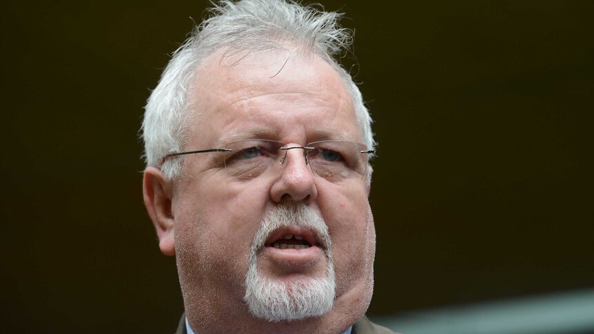 Senator Barry O'Sullivan close up of face and shoulders wearing a blue shirt and beige jacket.