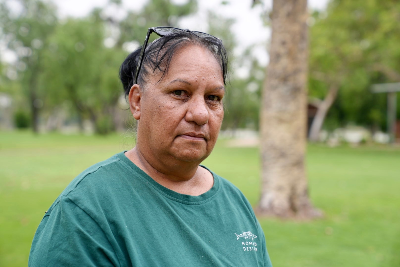 An Indigenous woman in a green t-shirt.