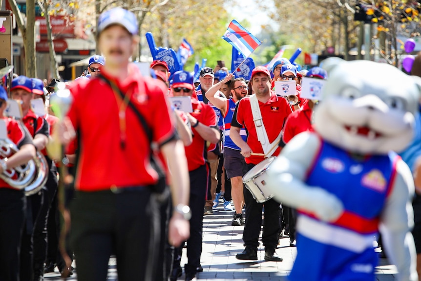 Western Bulldogs mascot blurred in the foreground with a crowd of people in the background
