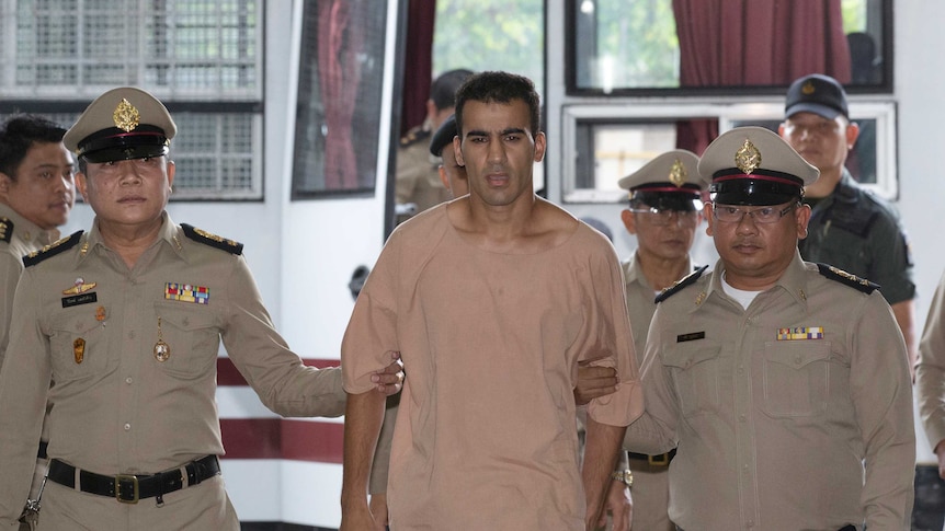 Hakeem al-Araibi is led by two police officers.