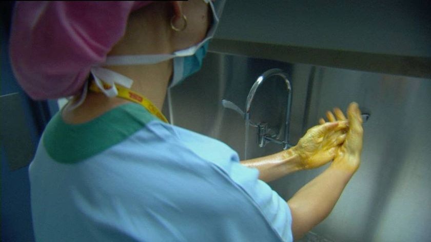 Nurse scrubbing up for work in an operating theatre