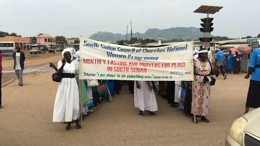 South Sudanese women march down a street.