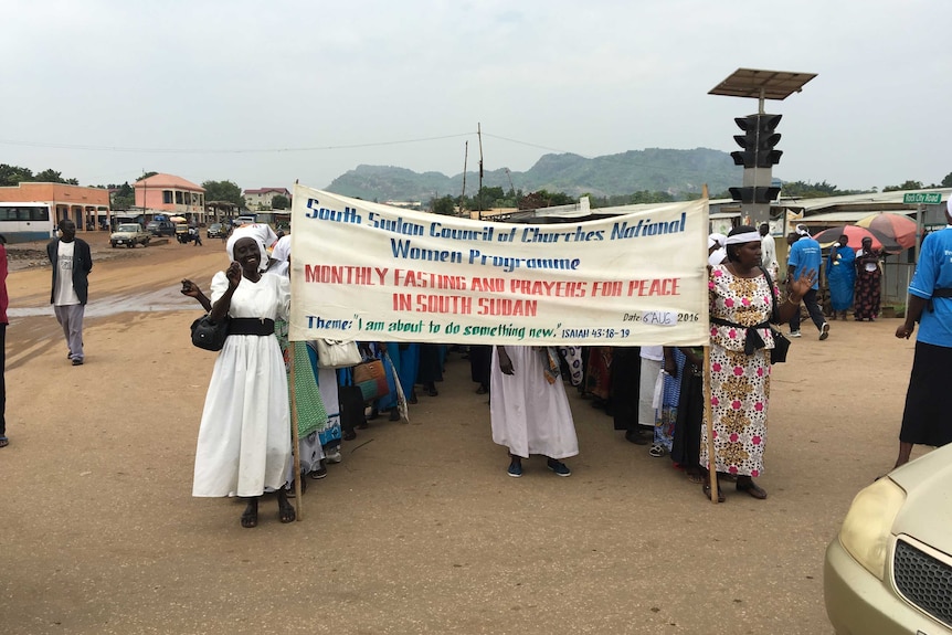 South Sudanese women march down a street.