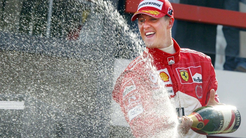 Michael Schumacher sprays champagne from the podium after the 2004 Belgium Grand Prix.