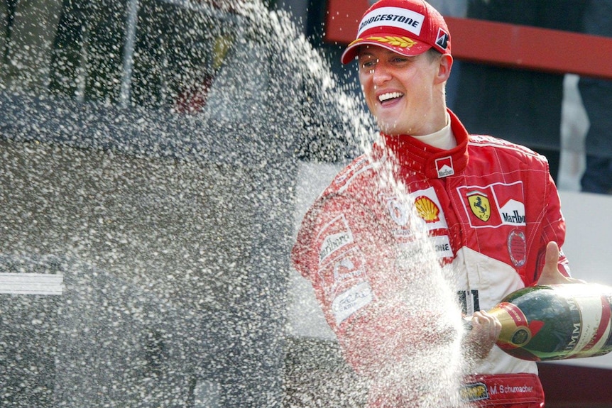 Michael Schumacher sprays champagne from the podium after the 2004 Belgium Grand Prix.