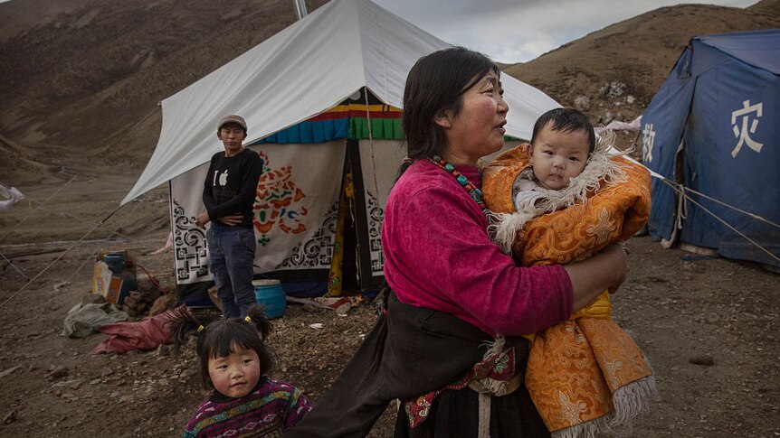 Perempuan Tibet dan dua anaknya di depan tenda.