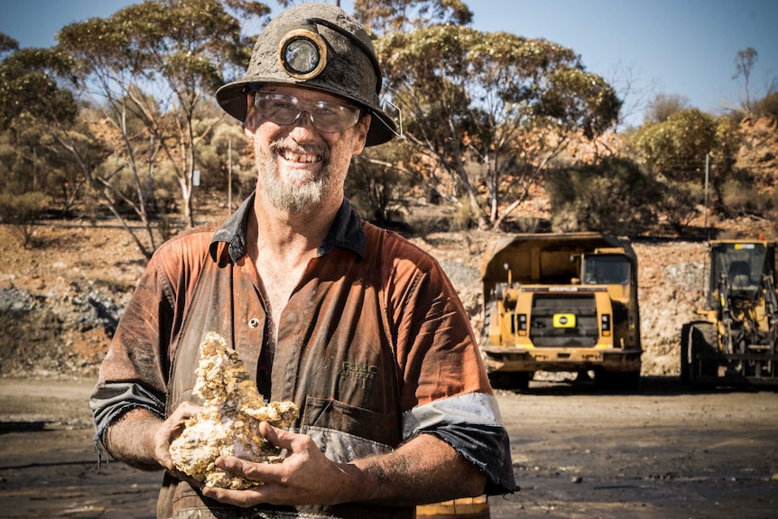 Miner holding gold specimen