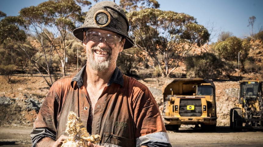 Miner holding gold specimen