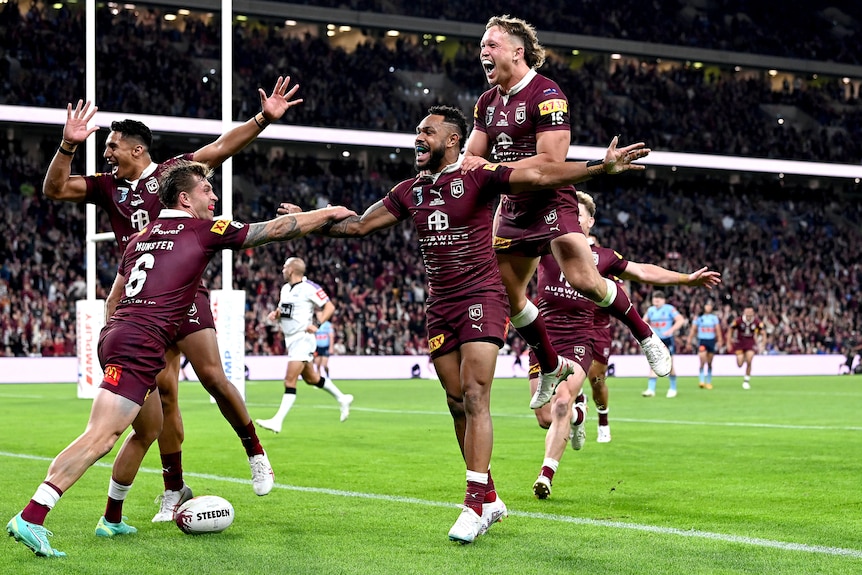 Queensland players leap on each other to celebrate