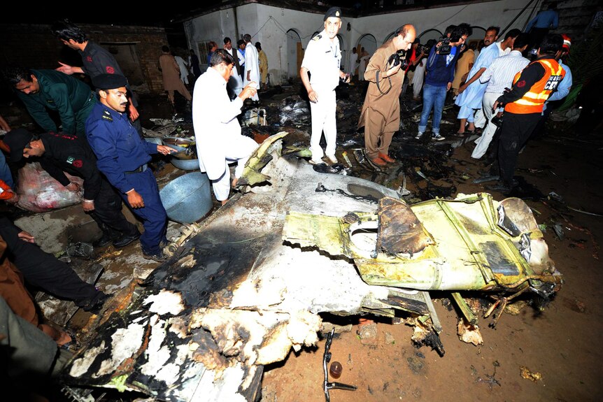 Rescue workers examine debris from Pakistan plane crash