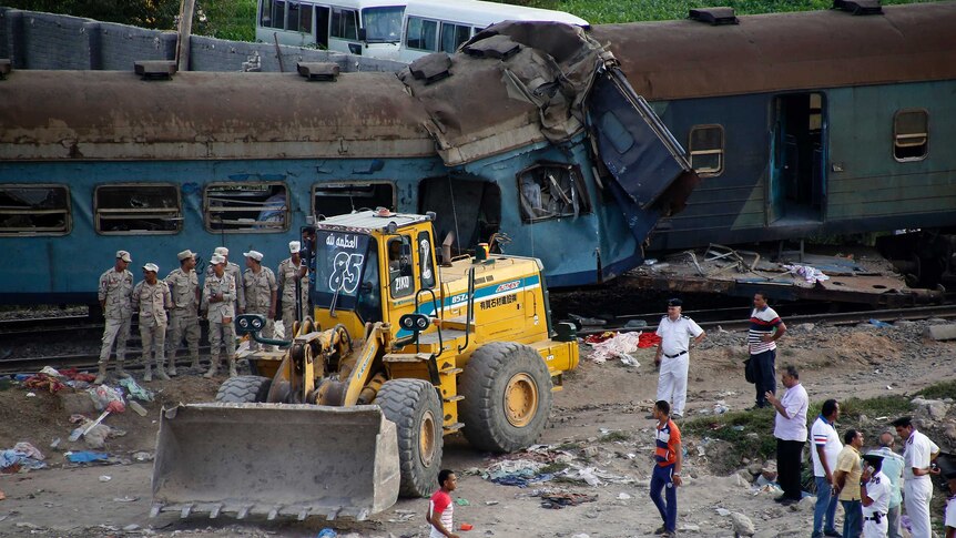 A bulldozer and military personnel near the crashed trains.