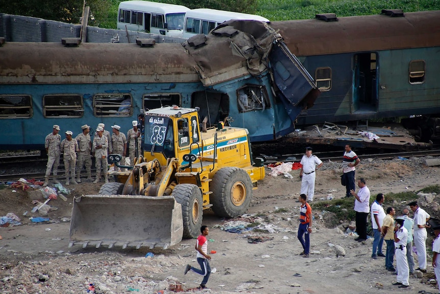 A bulldozer and military personnel near the crashed trains.