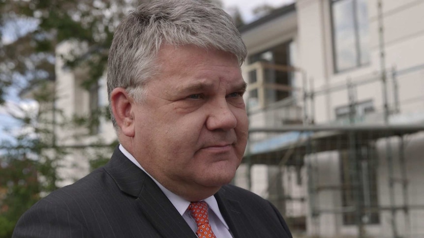 Stephen Koukoulas standing in front of a building under construction