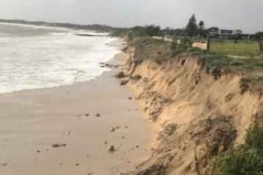 A coastline with a drop from the ground to the sand