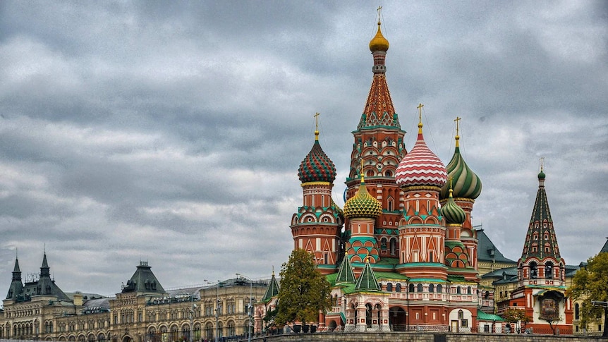 A colourful castle in Russia sits against a cloudy and gloomy sky
