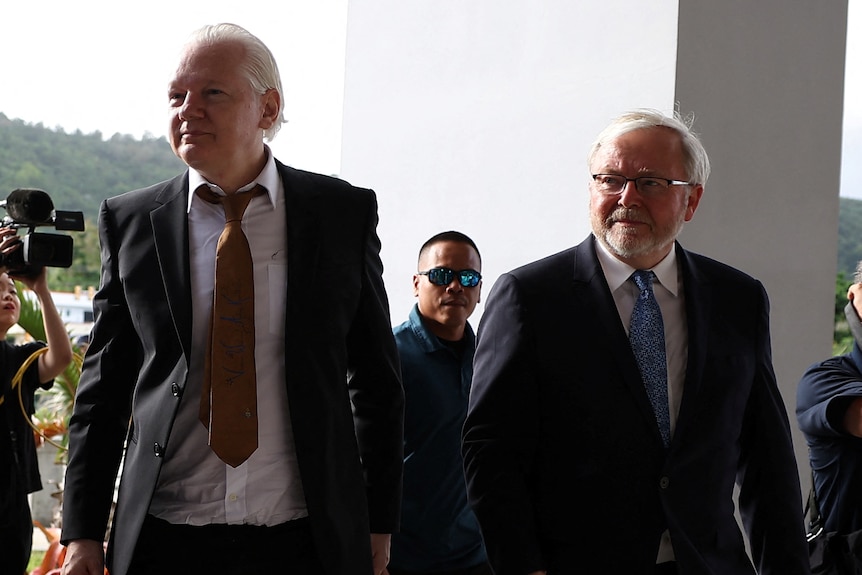 Two men in suits arriving at a courthouse for a hearing