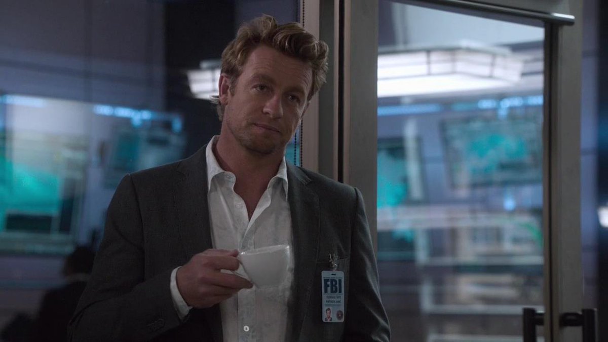 FBI agent holds cup of coffee while staring pensively into the distance