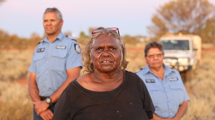 A Warakurna resident stands with police officers Wendy Kelly and Revis Ryder.