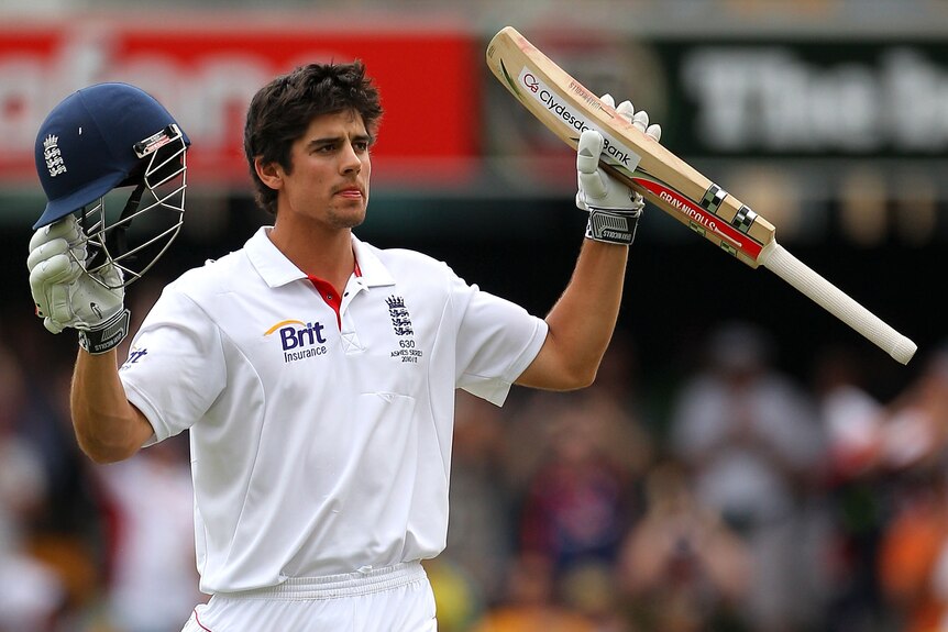 Alastair Cook holds his helmet and bat up