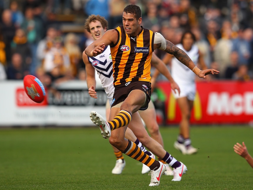 Hawthorn AFL star Lance Franklin runs and kicks towards goal with his left foot as defenders chase him.