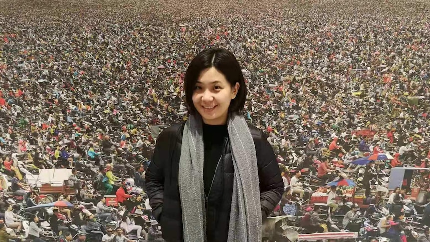 Iris Zhao stands in front of a collaged backdrop.