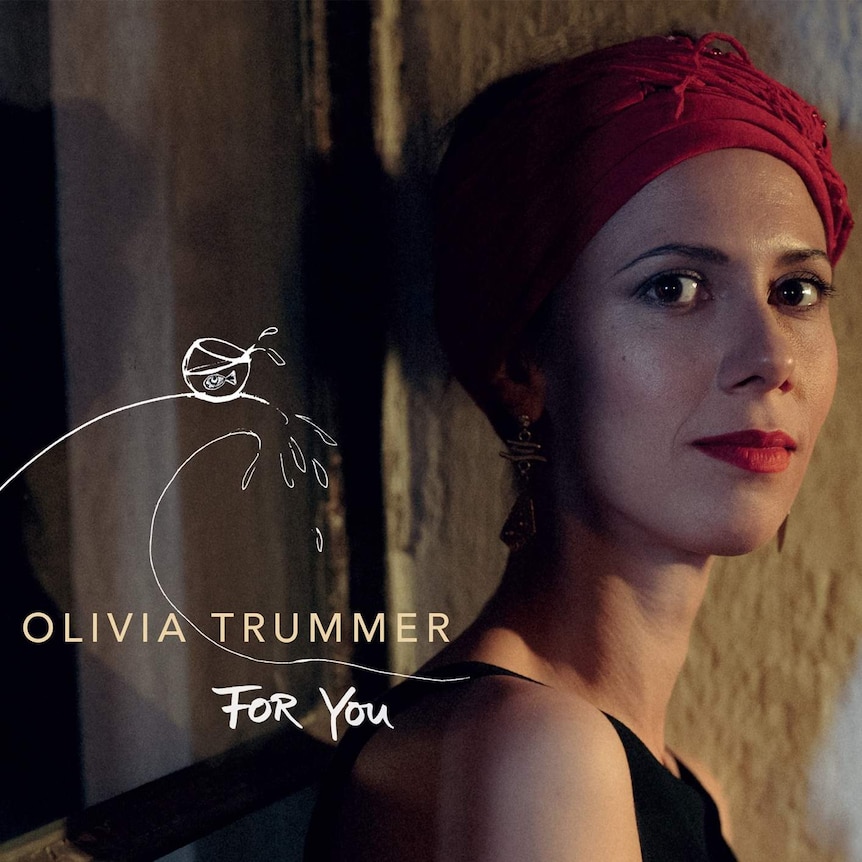 Olivia Trummer wearing a red headscarf and looking into the camera.