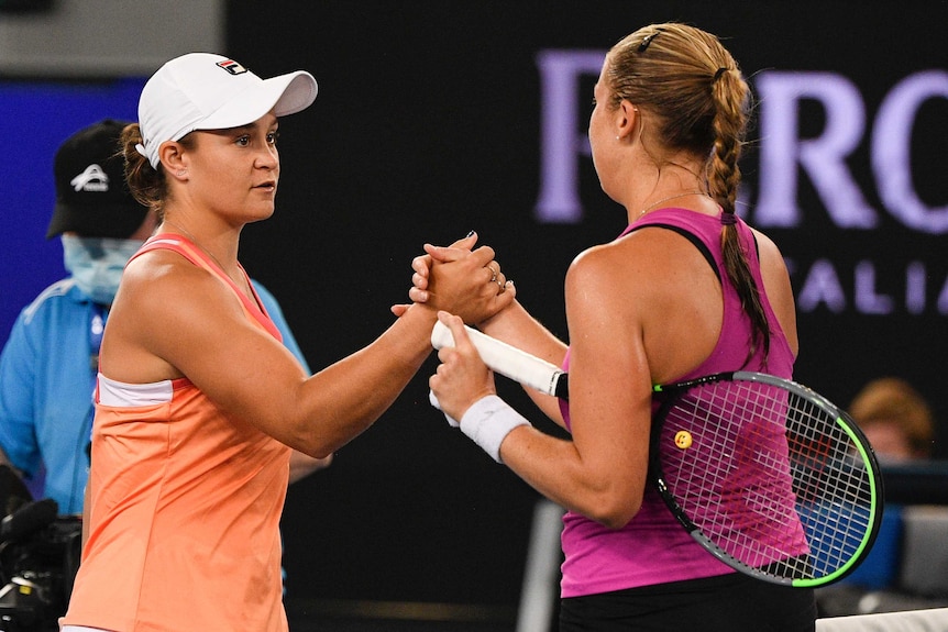 Two female tennis players shake hands at net after a warm-up match ahead of the Australian Open.