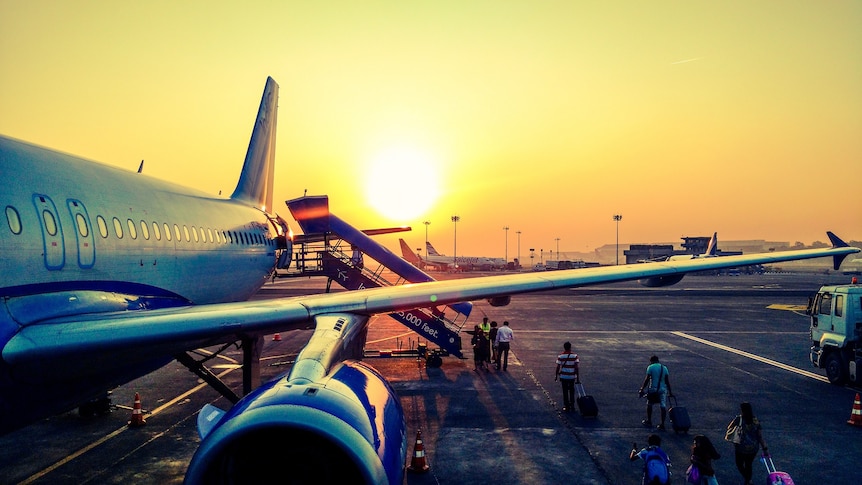 Picture of a plane with yellow sky behind for a story about taking money overseas