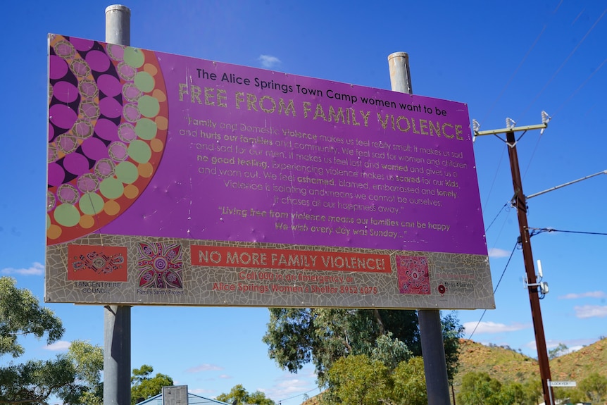 A pink sign which reads 'Free From Family Violence' with lots of words underneath is outside.