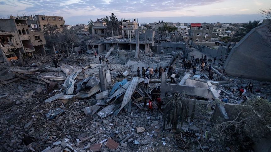 Palestinians look at a mosque destroyed in an Israeli strike in Rafah.