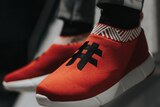 a pair of red sneakers with a hashtag on top