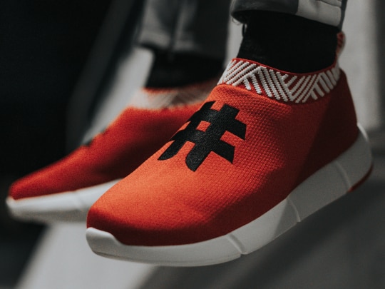 a pair of red sneakers with a hashtag on top