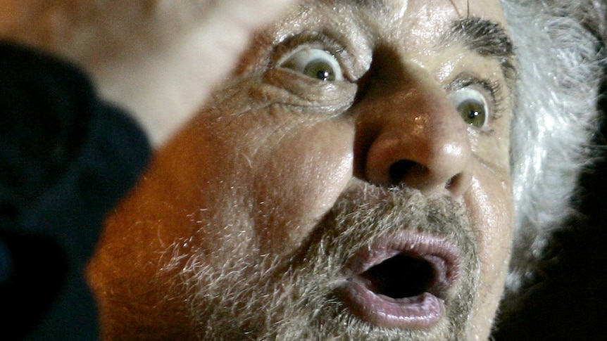 Beppe Grillo waves to supporters.