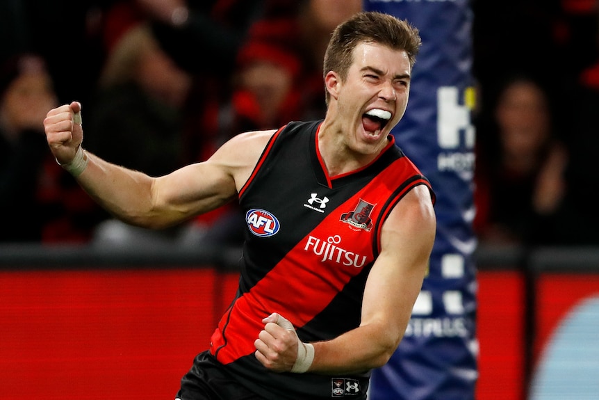 Zach Merrett bangs his fists as he celebrates an Essendon goal in the AFL.